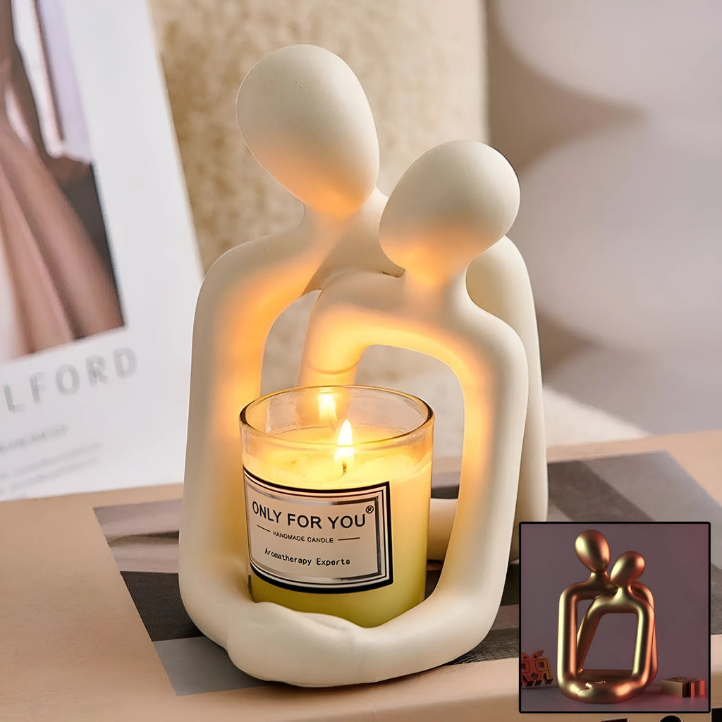 Modern minimalist resin statue of a couple in milky white or gold finish on a wooden surface.