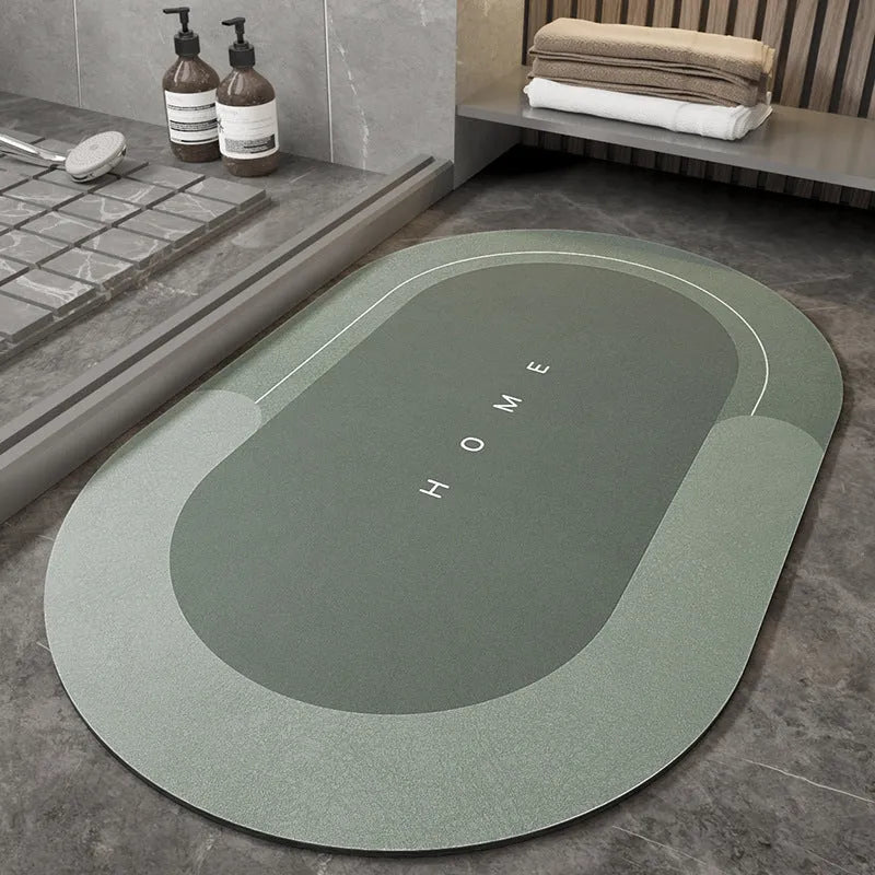 Machine woven bathroom floor mat in blue colour, shown in an oval shape on a tiled floor.