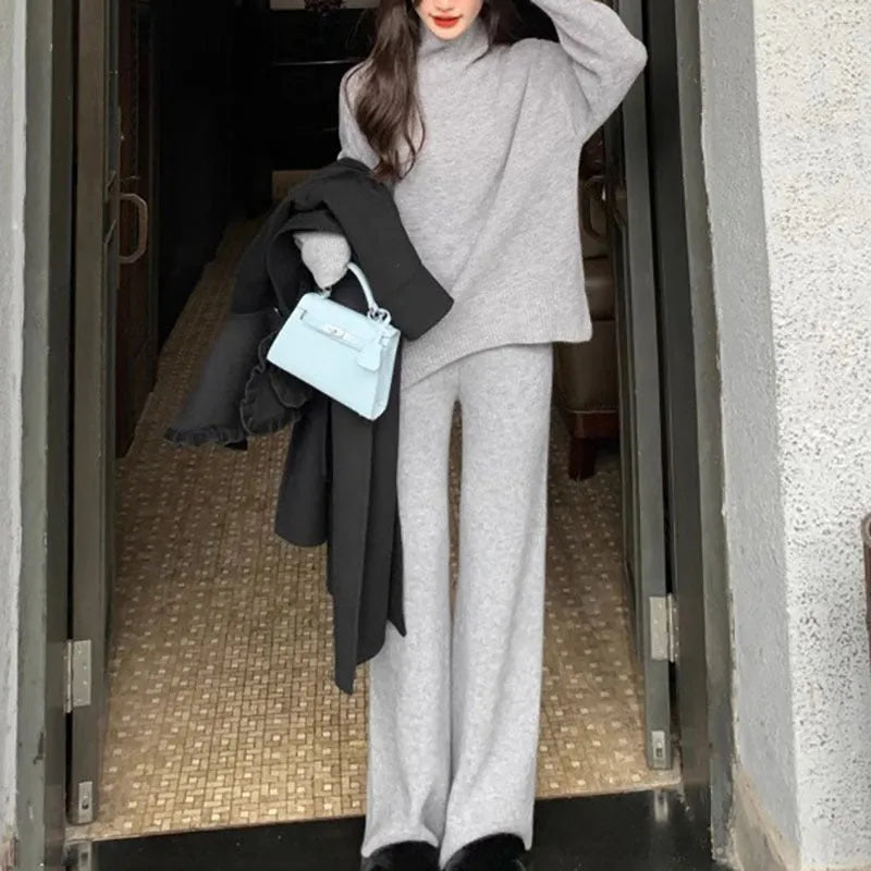 Women's milky white acrylic knit two-piece set featuring a long-sleeve sweater and wide-leg trousers on a hanger.