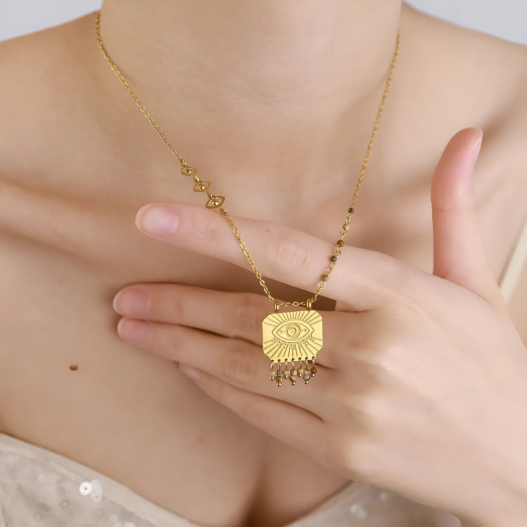 Retro gold titanium steel chain necklace with square natural stone pendant and evil eye motif on white background