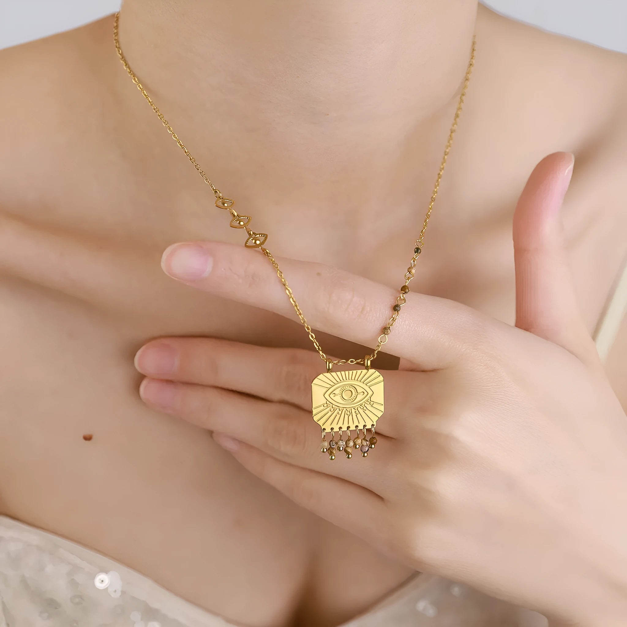 Retro gold titanium steel chain necklace with square natural stone pendant and evil eye motif on white background