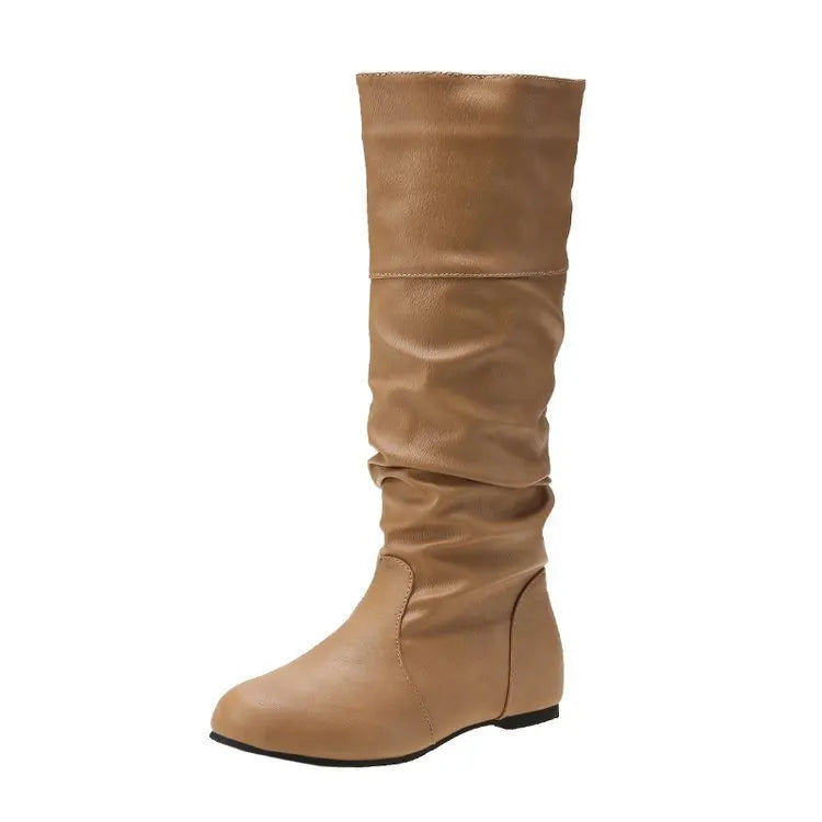 Women's black flat slip-on ankle boots with round toe and high cylinder cut, showing rubber sole.