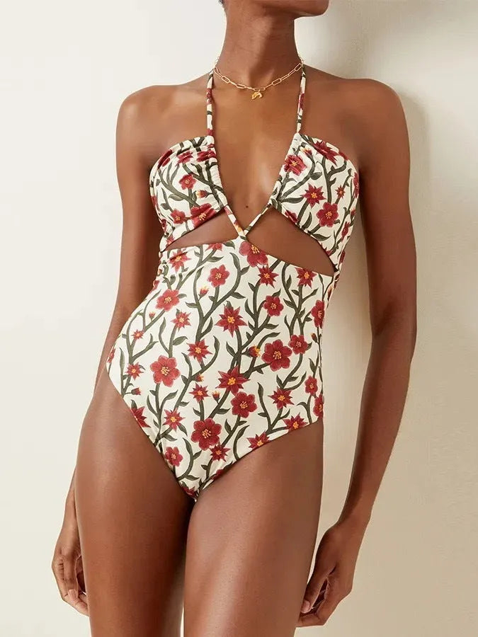 Female model wearing two-piece halter neck swimsuit with floral print and hollow-out gauze skirt cover-up