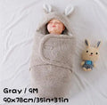 Baby wearing a grey adjustable fleece swaddle sleep sack with velcro wings