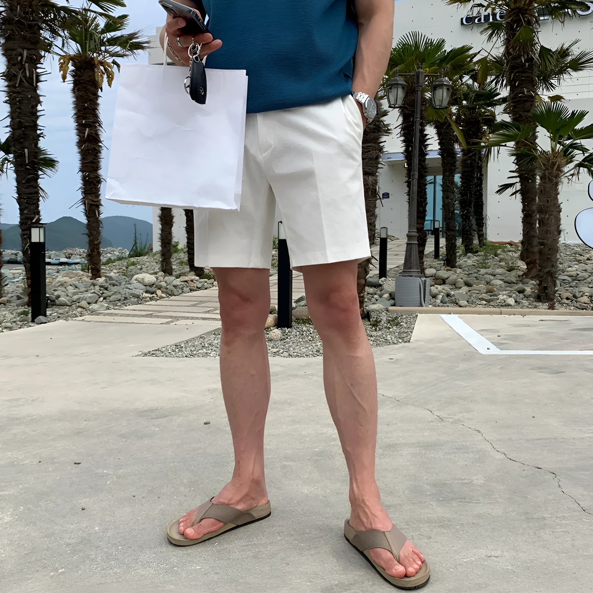 Men's straight-leg polyester shorts in solid black colour showing loose casual fit