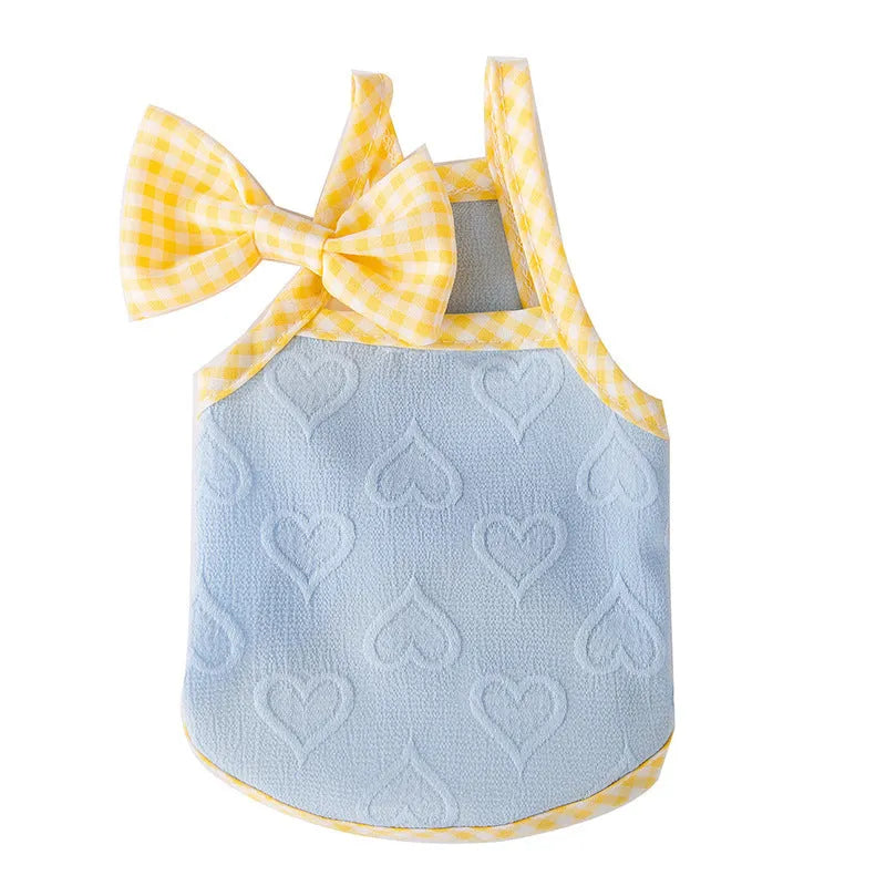 Small dog wearing a blue elastic vest with a heart texture and bow suspenders.