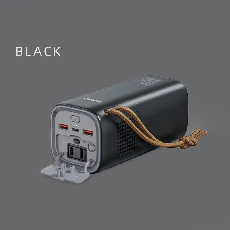 Black portable power bank with 220V socket, digital display, and solar panel on a wooden table.