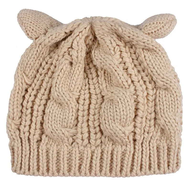 Handmade red knitted beanie with 3D cat ears and a pom pom on a mannequin head