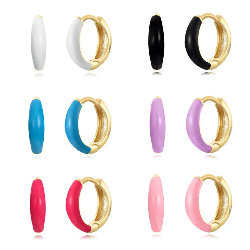 A pair of oval-shaped, U-curved epoxy earrings in a solid colour on a plain background.