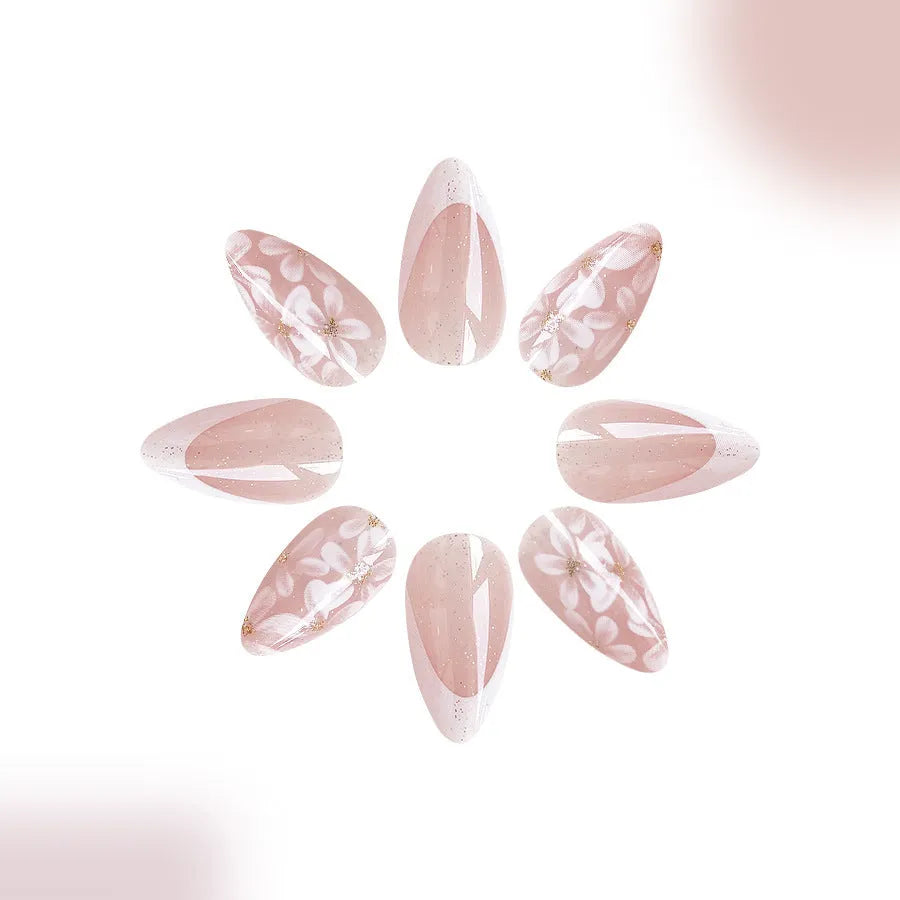 Short almond shaped false nails with glossy finish, glitter, and powder flower design in C625 colour.