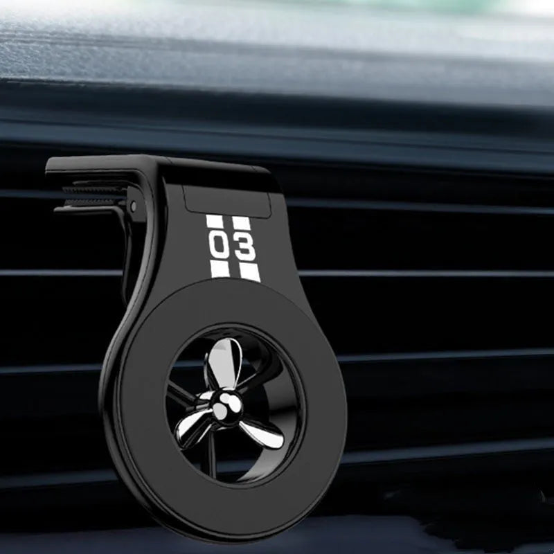 Black magnetic car phone holder clipped to a car air vent, holding a smartphone.