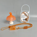 Small pink mushroom-shaped silicone chew pendant on a thin silver-coloured breakaway necklace.