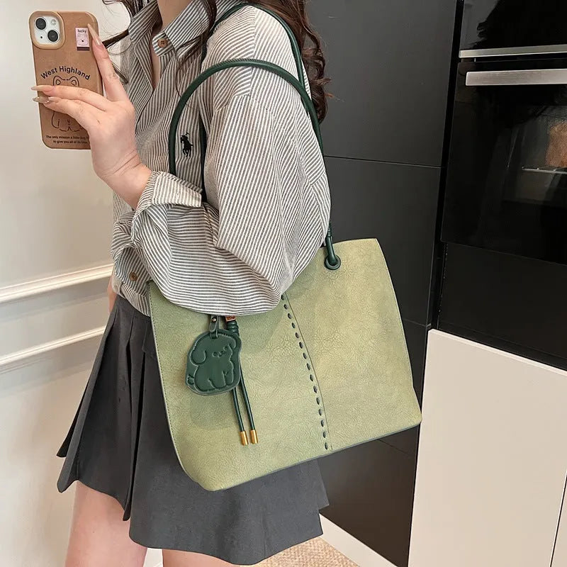 Green urban minimalist PU shoulder bag with stitching detail and double straps on a white background.