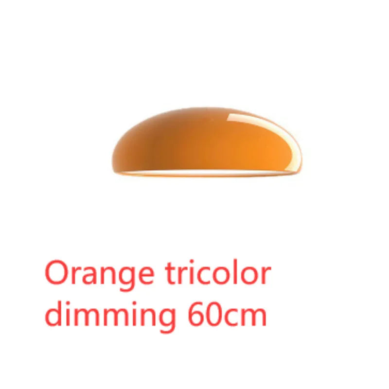 Orange iron Danish-style pendant lamp with adjustable cable above a restaurant table.