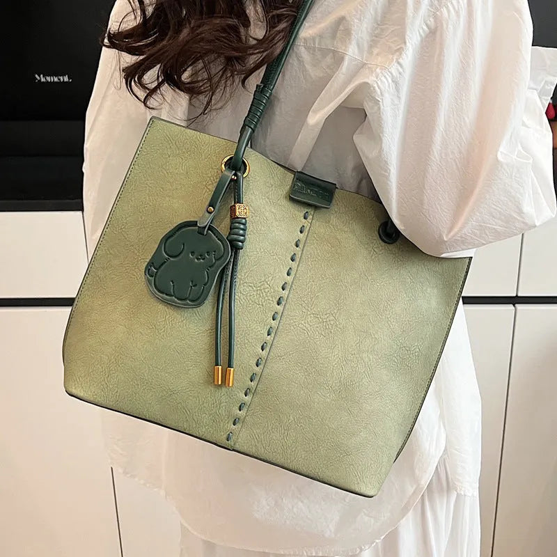 Green urban minimalist PU shoulder bag with stitching detail and double straps on a white background.