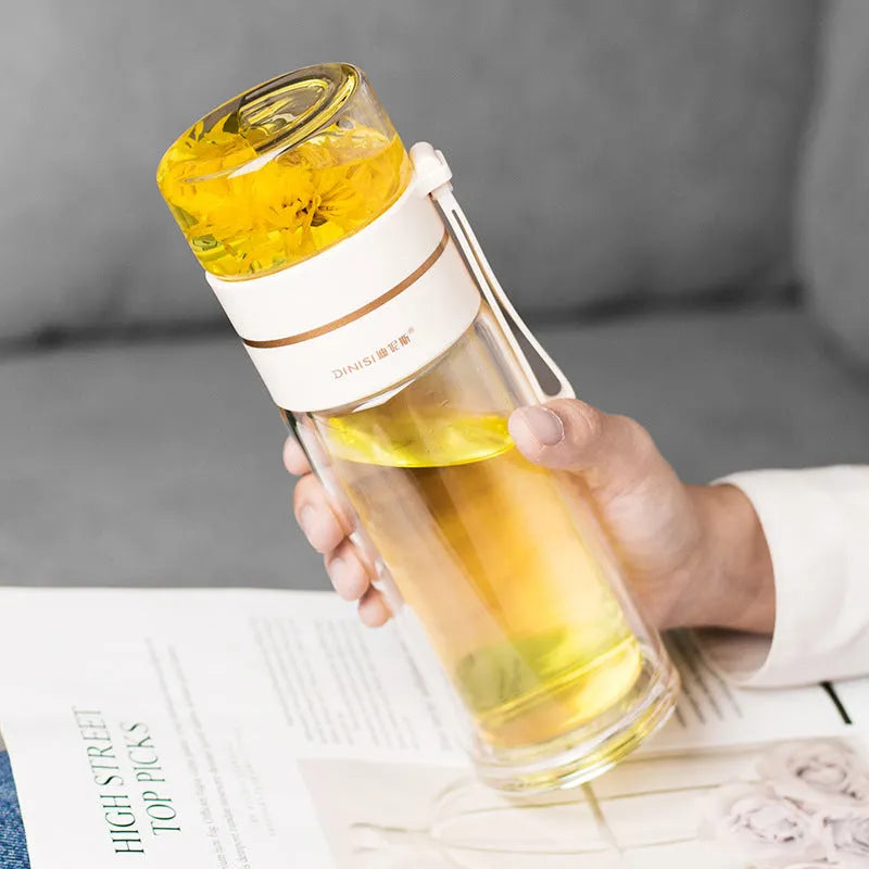 Green double-wall glass water bottle with a stainless steel tea infuser insert and a black leak-proof lid with rope handle.