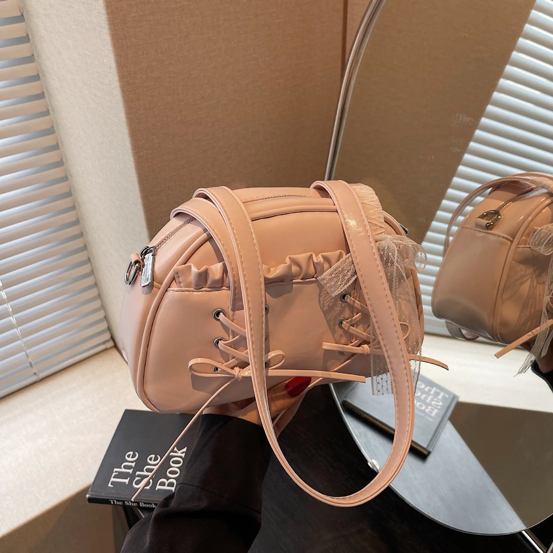Women's casual PU leather shoulder bag with a bandage bow design and internal phone compartment.