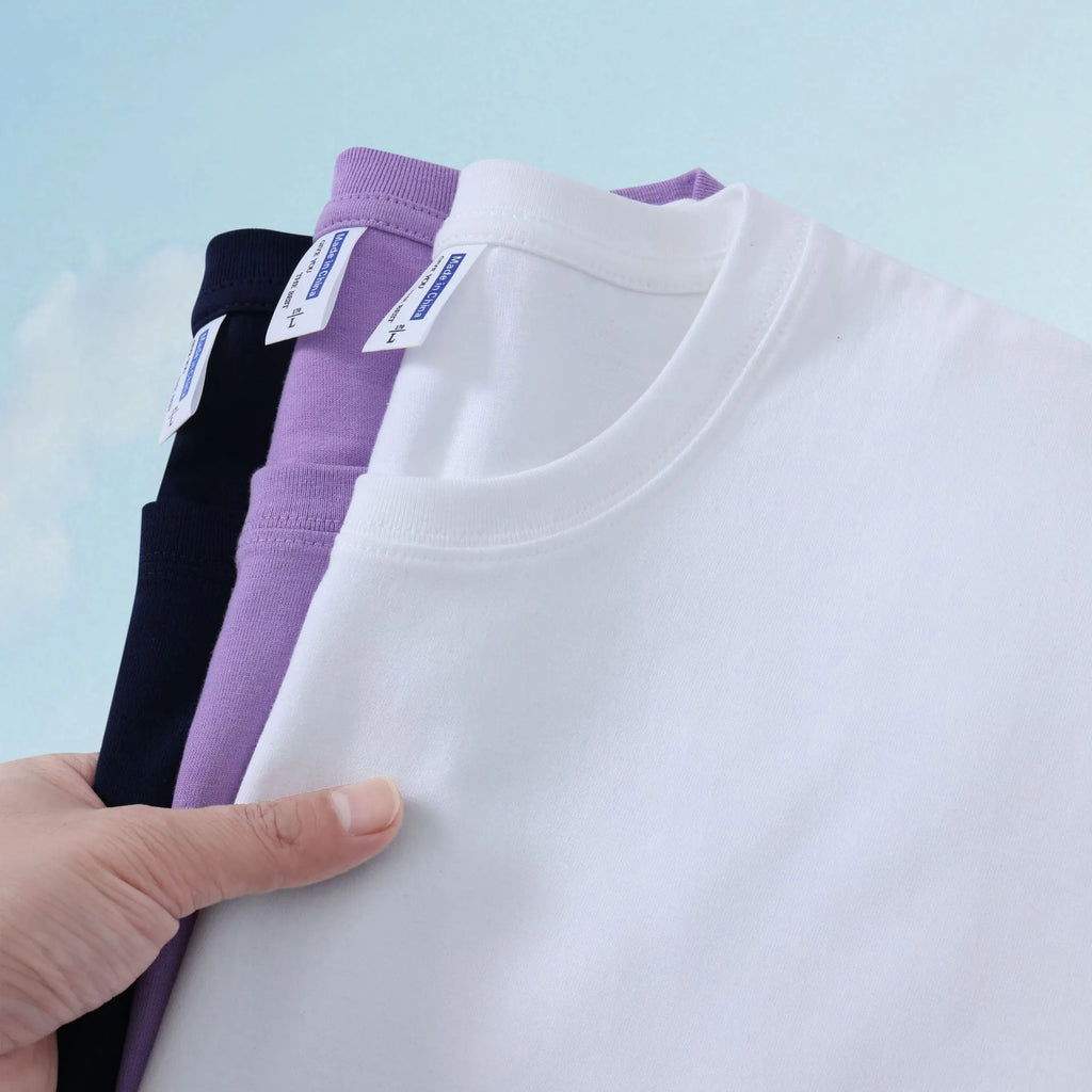 Unisex loose fit cotton t-shirt shown in multiple solid colours including navy blue, red, and white