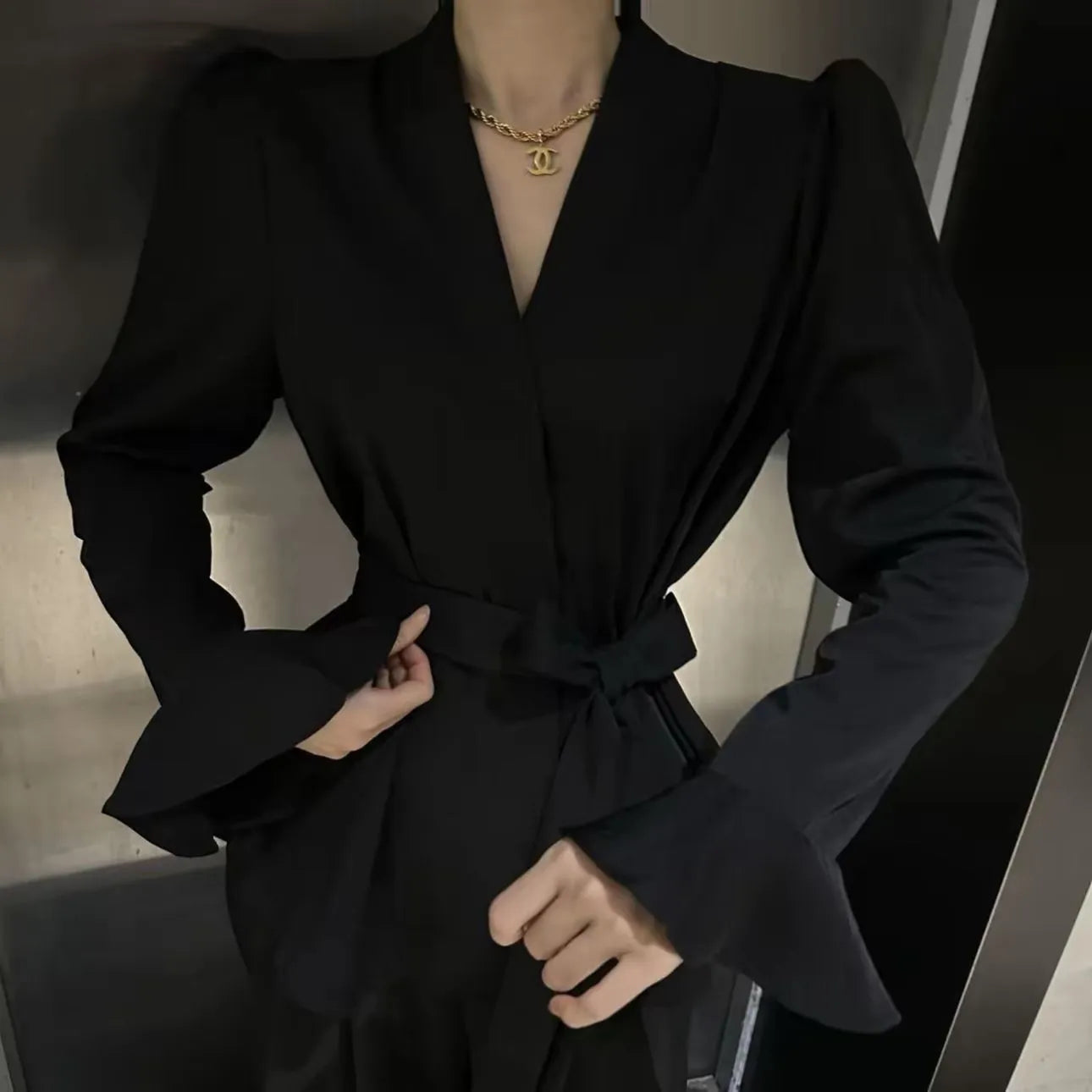 Women's black French-style shirt with an irregular collar and long bell sleeves, tied at the front.