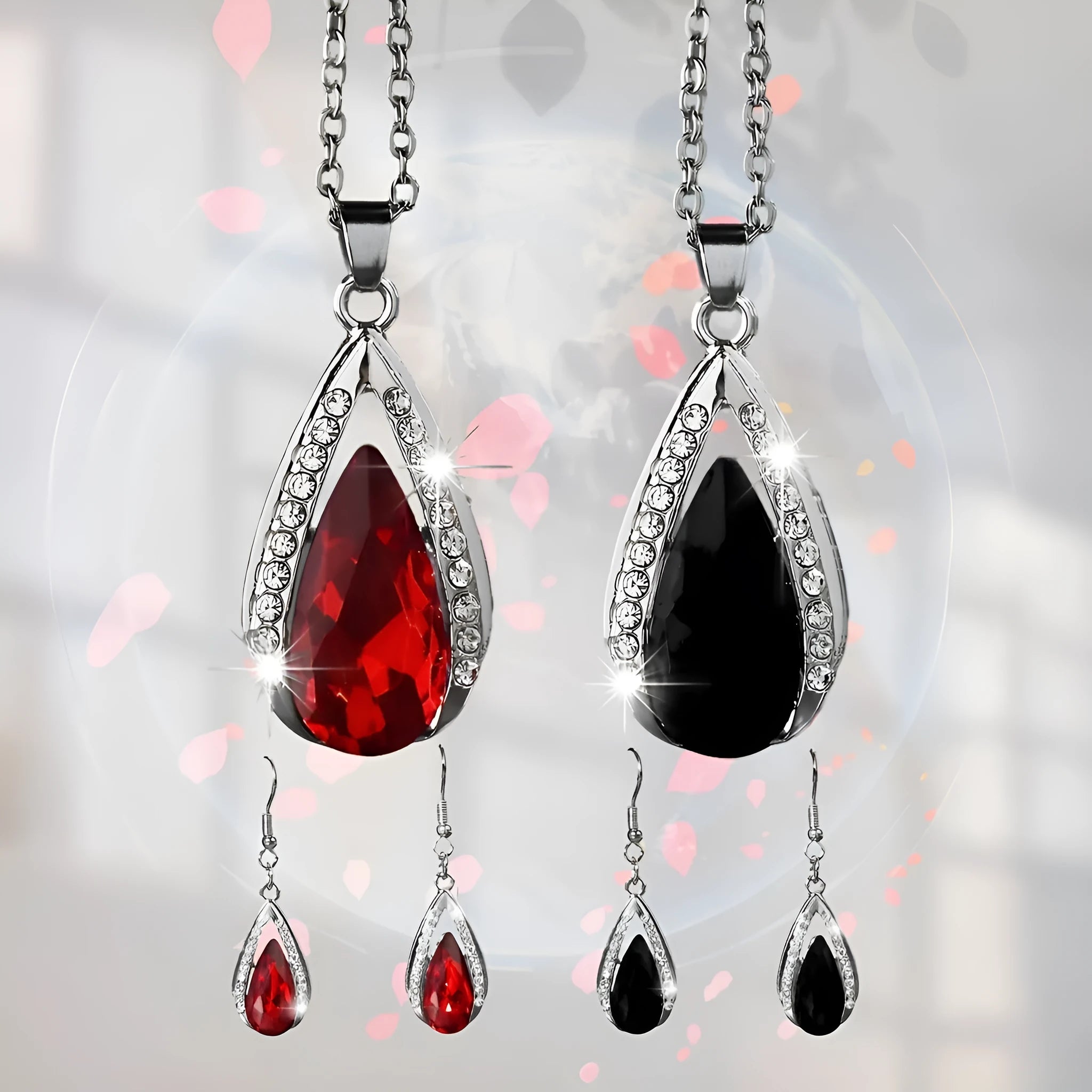 Black and red teardrop glass pendant necklace and matching earrings set on a grey background