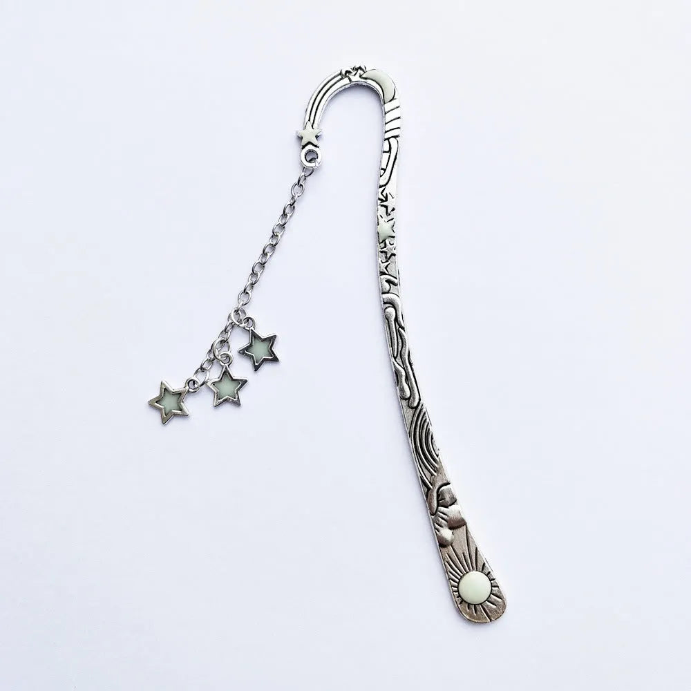 Metal bookmark with glowing five-pointed star and celestial sun moon stars design