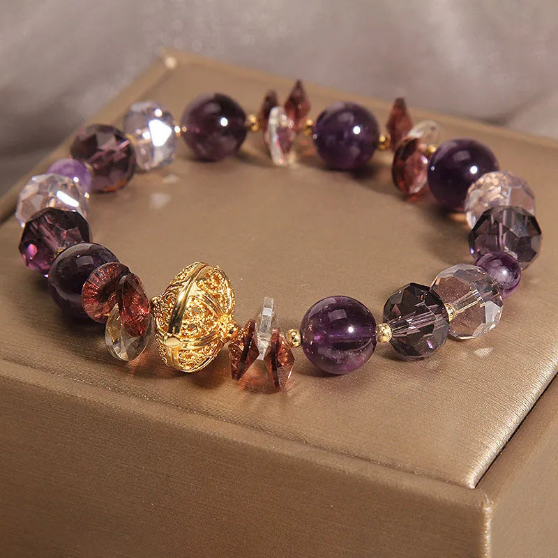 Purple crystal bracelet with pumpkin beads and rhinestone decoration on a wrist.