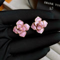 Gold plated purple oil-spot glaze 3D flower stud earrings with surgical steel posts on a white background.