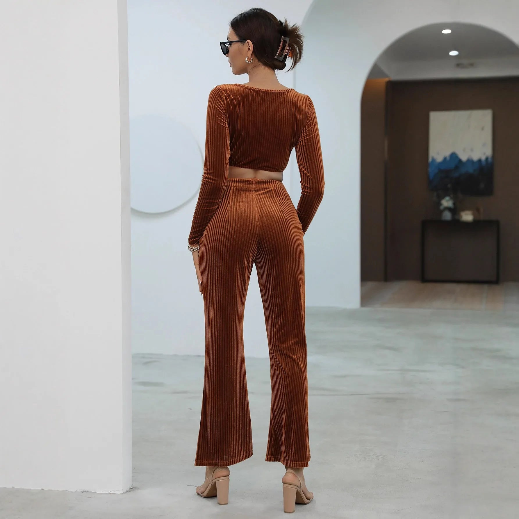 Caramel coloured women's long sleeve sweater and matching straight-leg trousers set on a hanger.
