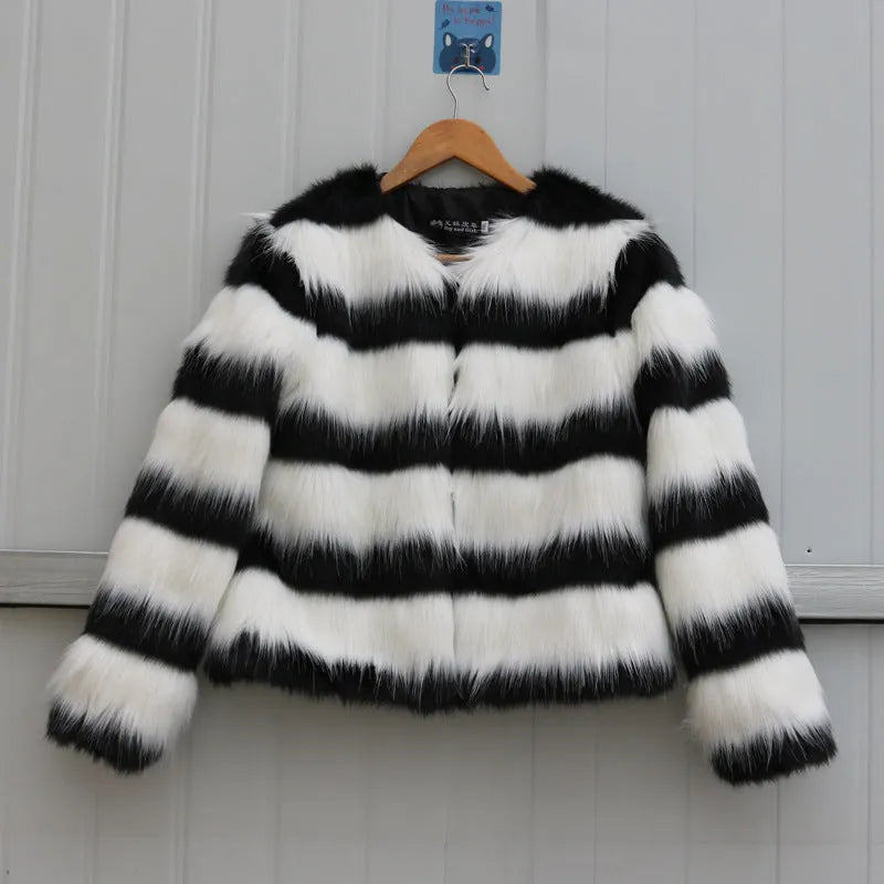 Long-sleeved black and white striped faux fur jacket for women on a grey background.