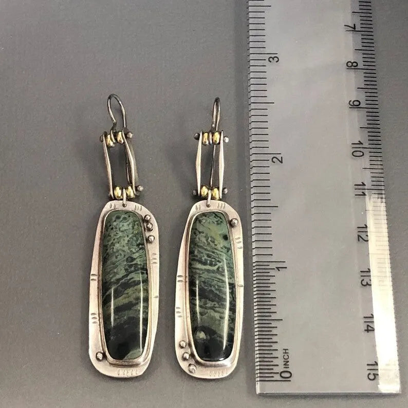 A pair of geometric drop earrings with a white and grey marble pattern on an alloy background.