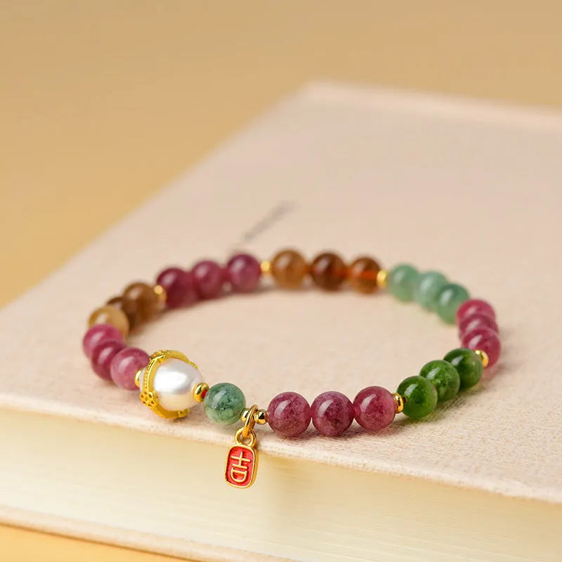 Geometric chalcedony stone bracelet with tourmaline colour beads on a wrist.