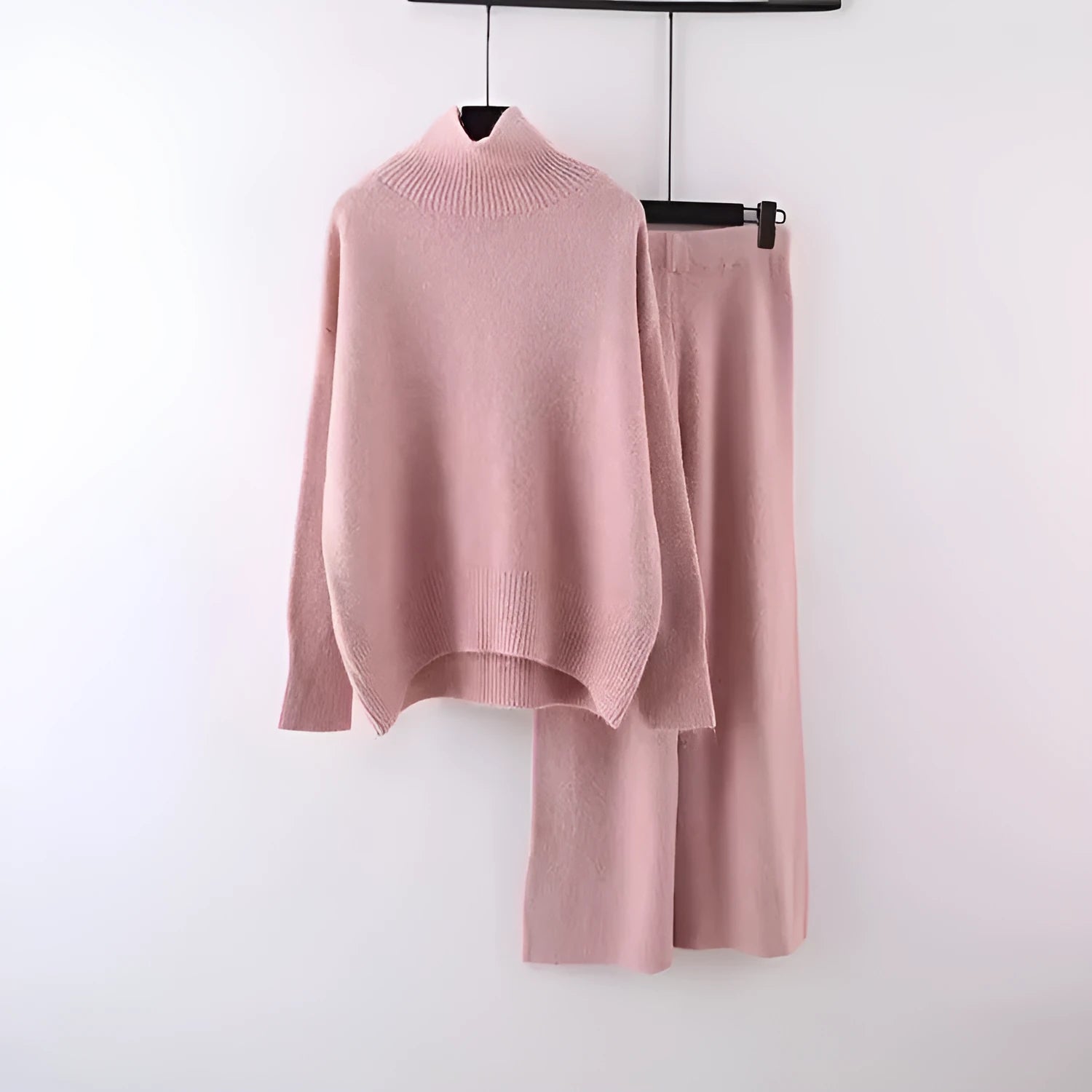 Women's milky white acrylic knit two-piece set featuring a long-sleeve sweater and wide-leg trousers on a hanger.