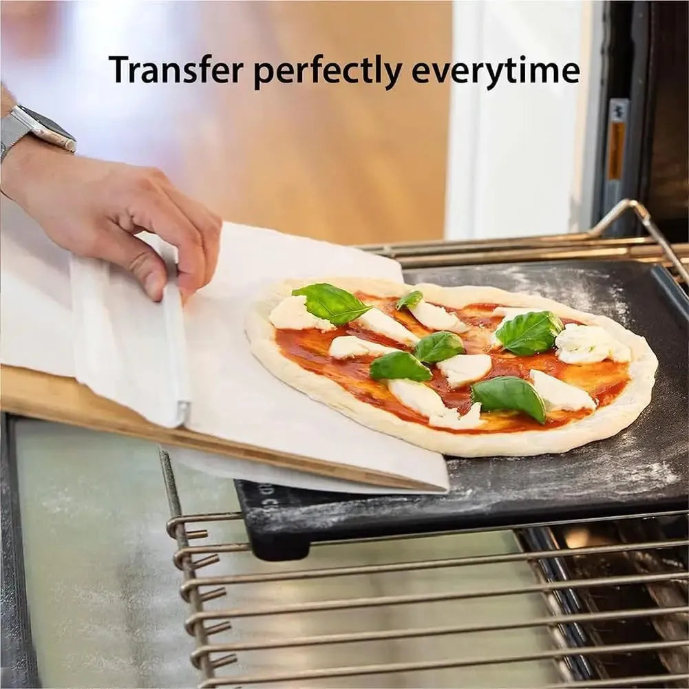 White food-grade PP plastic pizza transfer shovel with a hanging hole, shown on a kitchen counter.