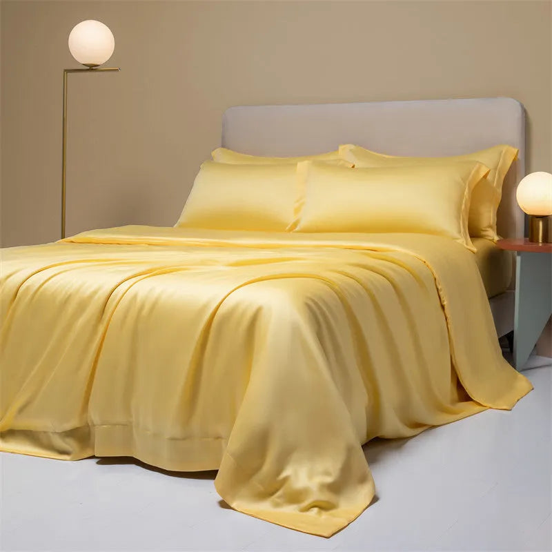 A neatly made bed with a Lenzing Tencel duvet cover and pillowcases in a soft grey colour.