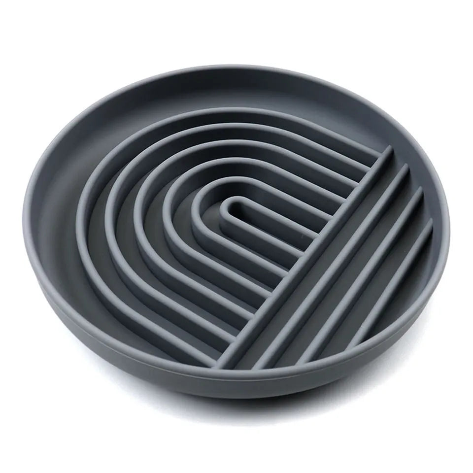 Beige silicone dog slow feeder bowl with ridges, shown next to a grey blue version on a wooden floor.