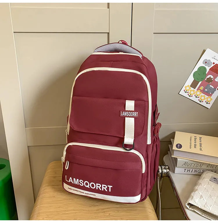 Waterproof nylon school backpack in colour options with curved shoulder straps and pendant attachment