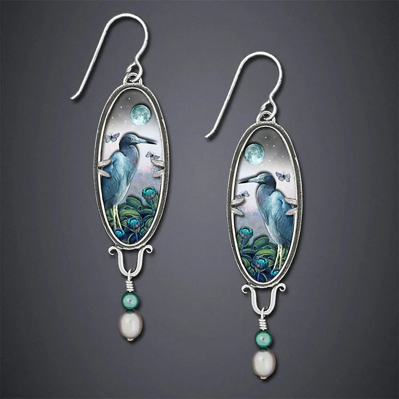 Silver retro-style drop earrings with a creative bird and flower design.