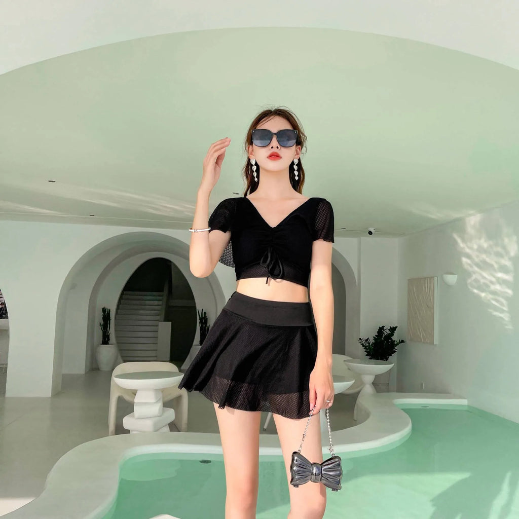 Women's solid colour two-piece swimsuit with a separate top and skirt.