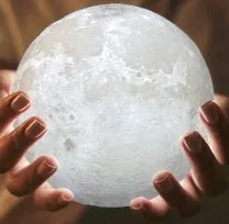 3D printed white moon lamp with detailed lunar surface texture on a wooden holder.