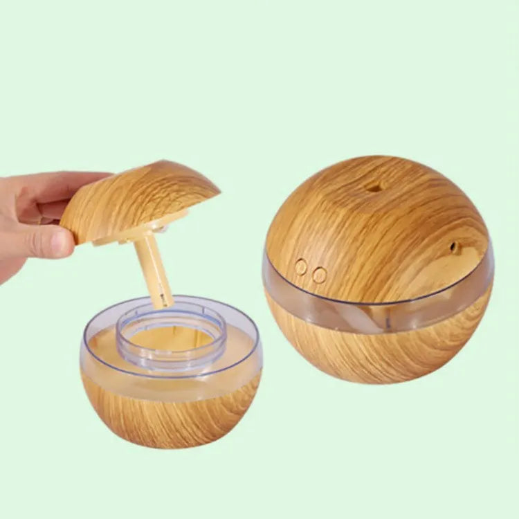 Brown wood grain portable USB humidifier on a desk next to a laptop.