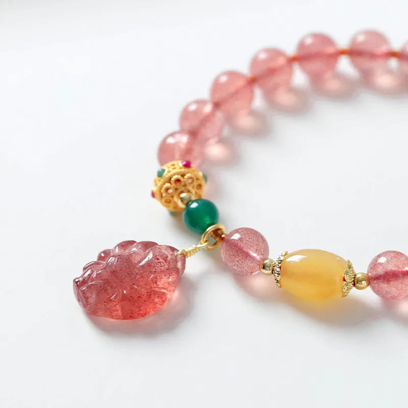 Women's polished crystal beaded bracelet with strawberry quartz and a nine-tail fox charm.