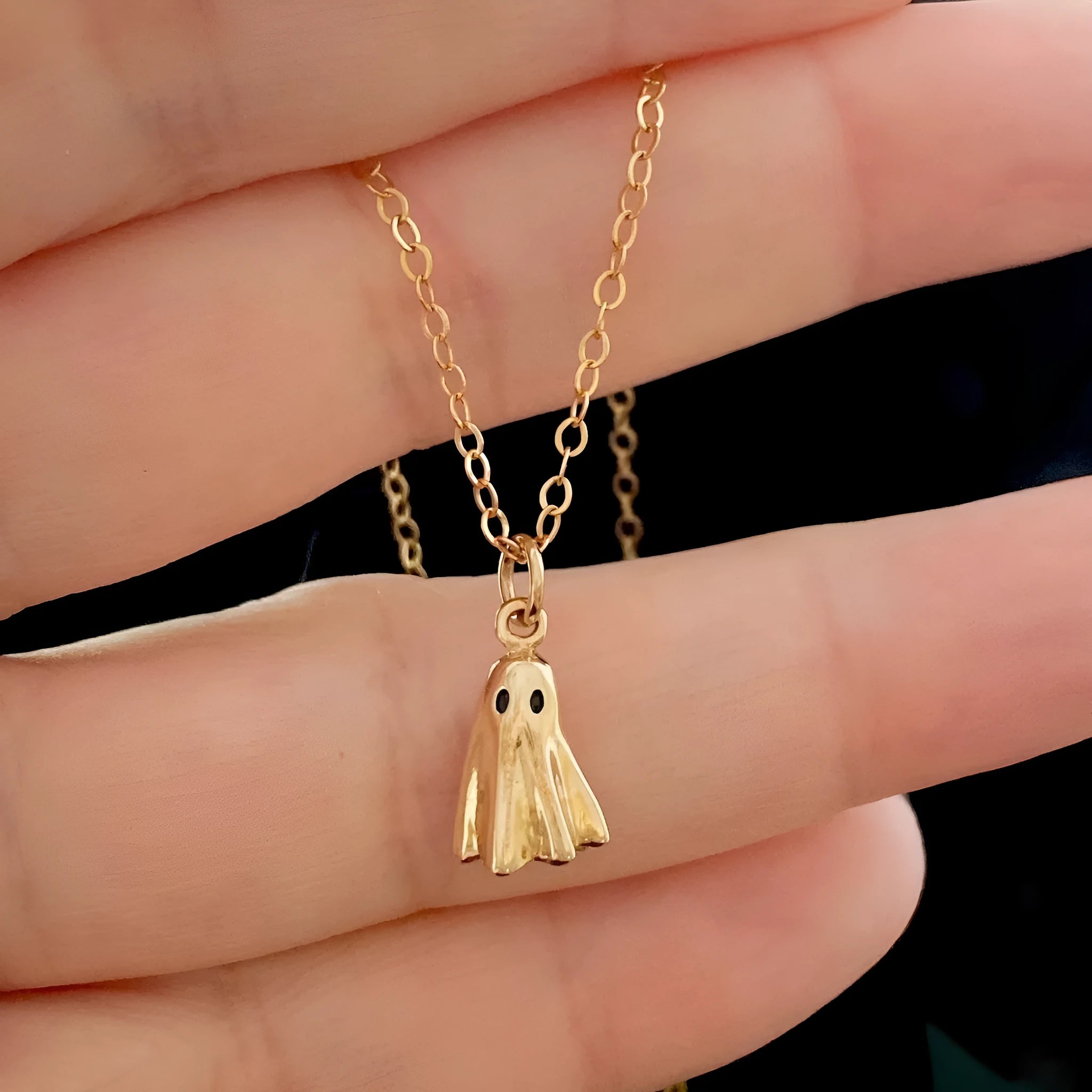 Stainless steel ghost pendant necklace on a twisted chain, showing titanium steel charm.