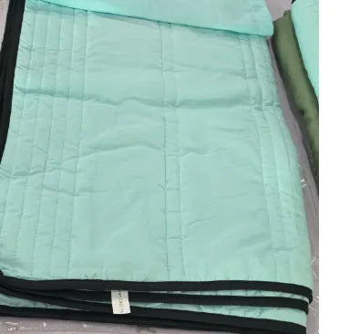 Lightweight seersucker summer quilt in various colours on a bed