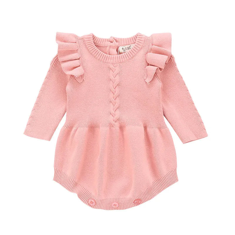 Baby girl wearing a soft pink cotton princess-style romper with a hedging placket.