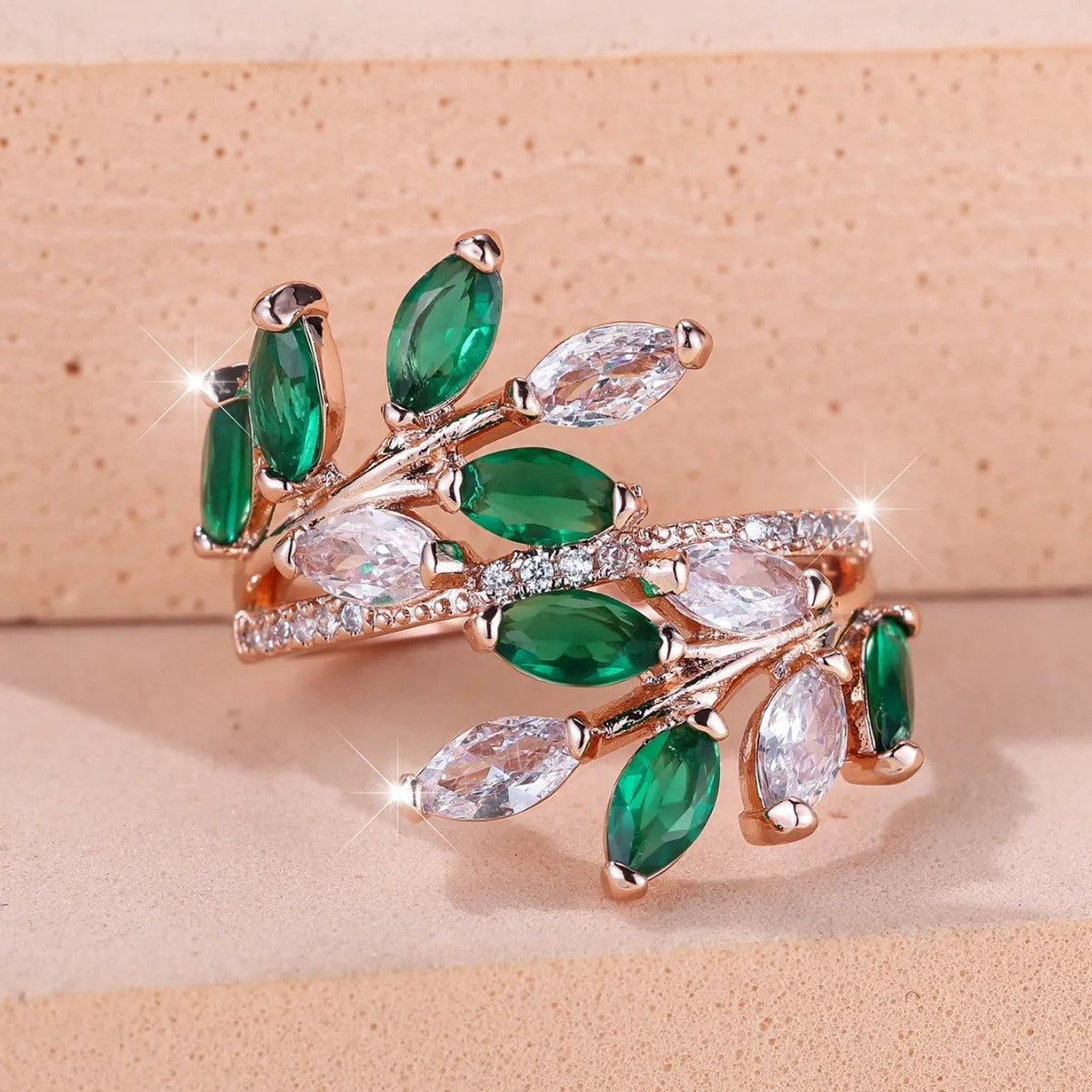 Adjustable copper leaf-shaped ring with sparkling zircon stones in rose gold and platinum finishes.
