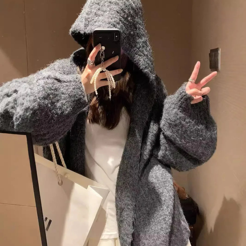A woman's loose-fitting, hooded sweater cardigan in a solid colour, shown with regular sleeves.