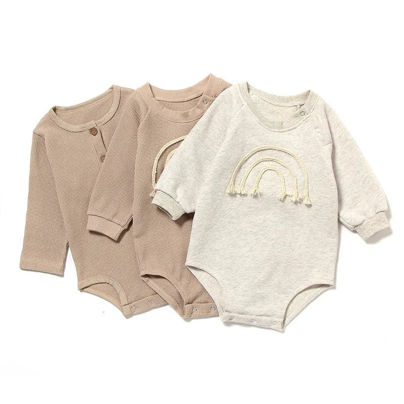 Infant wearing a beige waffle cotton long sleeve romper climbing suit