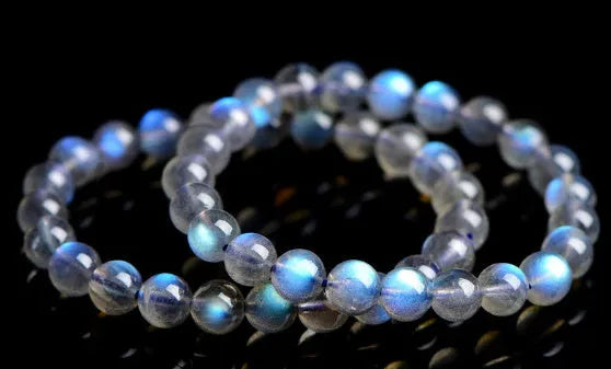 Natural blue moonlight crystal bracelet with cream body beads on a white background.