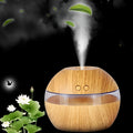 Brown wood grain portable USB humidifier on a desk next to a laptop.