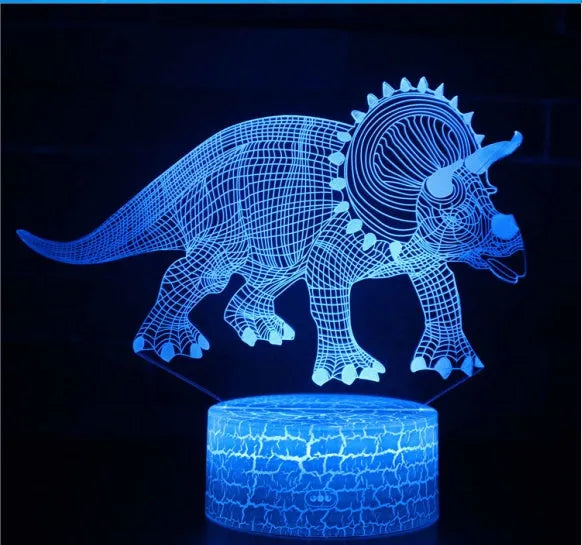 Colourful dinosaur 3D night light with remote control on a bedside table.